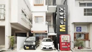 two cars parked in a parking lot in front of a building at Mcity in Maejima - Vacation STAY 54881v in Naha