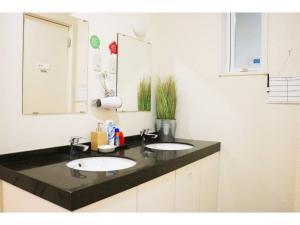 a bathroom with two sinks and a mirror at OHANA TOKYO HOUSE - Vacation STAY 73657v in Tokyo