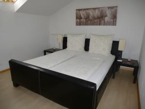 a black bed with white sheets and pillows in a room at Haus Panoramablick in Endingen +3 photos