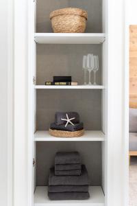 a book shelf with towels and wine glasses at Vent du Vent 402 - Vacation STAY 83691v in Urasoe