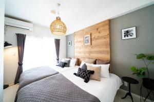 a bedroom with a large bed with a wooden headboard at Vent du Vent 402 - Vacation STAY 83691v in Urasoe