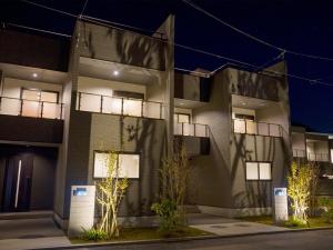 a building with lights on the side of it at night at Rakuten STAY Fuji Kawaguchiko Station - Japanese Modern Villa Mt Fuji View 105 in Fujikawaguchiko
