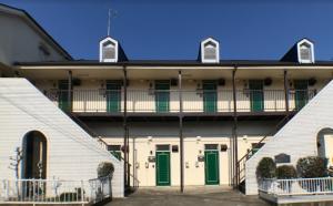 a white building with green doors and a balcony at Riverside Plaza Matoba - Vacation STAY 54884v in Kawagoe