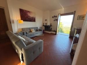 a living room with a couch and a table at Villa Rosanna - views and woods near Florence in San Donato in Collina
