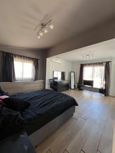 a bedroom with a bed and a desk and two windows at 3artı1 iki katlı daire in Aglantzia