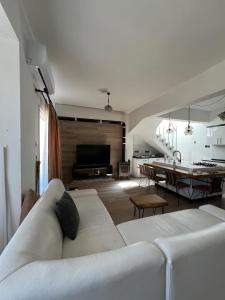a living room with a white couch and a table at 3artı1 iki katlı daire in Aglantzia