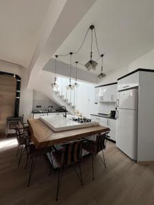 a kitchen with a wooden table and a white refrigerator at 3artı1 iki katlı daire in Aglantzia
