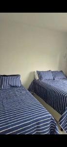 two beds sitting next to each other in a room at Flat Mar doce lar in Conde +44 photos
