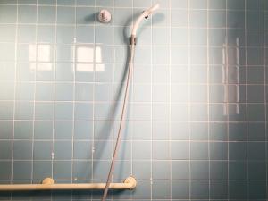 a shower with a hose in a blue tiled bathroom at Komorebi - Vacation STAY 91398v in Miyako Island +25 photos