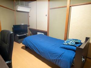 a bedroom with a bed and a television in it at Takayanagi Ryokan - Vacation STAY 88522v in Takamatsu