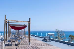 a wooden deck with chairs and tables and the ocean at Agri Museum NADA - Vacation STAY 93817v in Minamiawaji