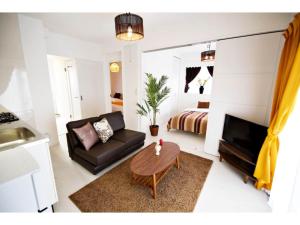 a living room with a couch and a table at Vent du Vent - Vacation STAY 83347v in Urasoe