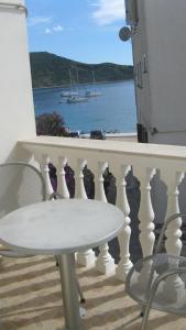 d'une table et de chaises sur un balcon avec vue sur l'eau. dans l'établissement Apartment Nizic, à Primošten