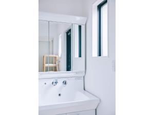 ein weißes Badezimmer mit Waschbecken und Spiegel in der Unterkunft Capetown Resort - Vacation STAY 96524v in Isumi + 65 Fotos