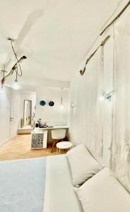 a white living room with a couch and a table at Il Ciclope - La camera sotto il faro in Termoli