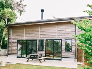 ein Haus mit einem Picknicktisch davor in der Unterkunft Capetown Resort - Vacation STAY 96524v in Isumi