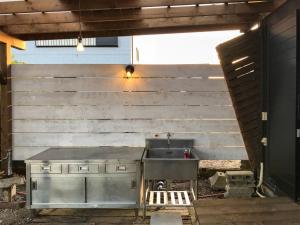 eine Küche mit einem Waschbecken neben einer Holzwand in der Unterkunft Lagoon Resort - Vacation STAY 96528v in Isumi