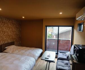 a bedroom with a bed and a couch and a window at MAHALO - Vacation STAY 05296v in Saikai