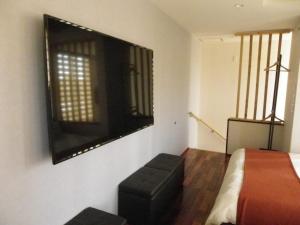 a bedroom with a bed and a tv on the wall at Guest House Jinya - Vacation STAY 05308v in Takayama