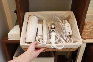 a person holding a basket filled with controllers and appliances at WAKURIAN,iwatacho - Vacation STAY 98982v in Okayama