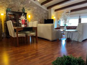 a living room with a couch and a table at Les Golfes de Can Mascarbo, mimar-te en un confortable espai in Sant Hilari Sacalm