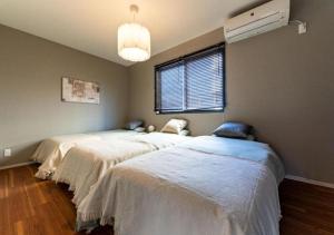 a room with two beds in it with a window at HAKATA TERRACE -akari- - Vacation STAY 12420 in Fukuoka