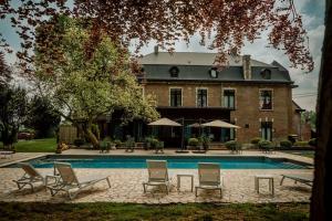 a house with a pool and chairs and a building at Relais M in Frasnes-lez-Anvaing