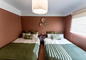 a bedroom with two beds and a chandelier at HAKATA TERRACE -hare- - Vacation STAY 12421 in Fukuoka