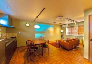 a kitchen and living room with a table and a couch at HAKATA TERRACE -hare- - Vacation STAY 12421 in Fukuoka