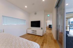 a bedroom with a white bed and a television at SEASIDE TERRACE SUN - Vacation STAY 12430 in Numazu