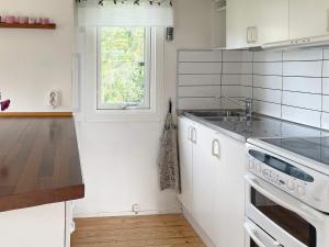 a white kitchen with a sink and a stove at 6 person holiday home in Gränna in Gränna +21 photos