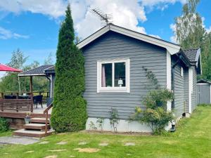 a blue house with a porch and a yard at 6 person holiday home in Gränna in Gränna