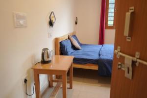 a room with a bed and a table with a telephone at Skyard Hostel & Homestay- Harsil Valley in Harsil