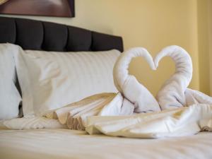 dos toallas con forma de cisnes sentados en una cama en Novus apartments, en Skala Marion