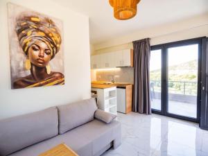 a living room with a couch and a painting of a woman at Novus apartments in Skala Marion