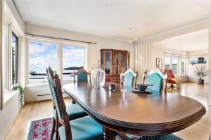 una sala da pranzo con tavolo e sedie in legno di Fjordside Escape - Spacious apartment with amazing views a Tysnes