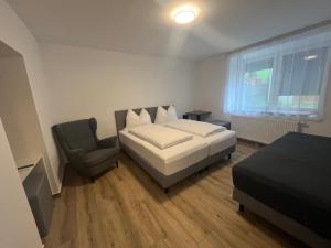 a bedroom with a bed and a chair in it at Apartments Laura in Oberweg
