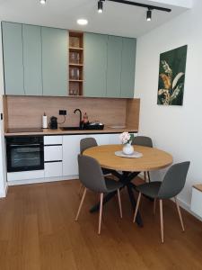 a kitchen with a wooden table and chairs in a room at Apartman Tri vrha Spa & Wellness Zlatibor in Zlatibor
