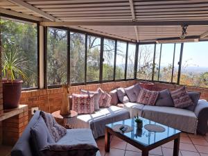 eine abgeschirmte Veranda mit Sofas und einem Tisch in der Unterkunft Edelweiss Corporate Guest House in Pretoria