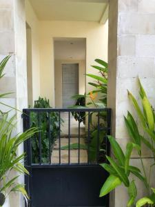 a balcony with a black railing and plants at Perela Homestay Canggu in Canggu