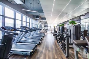 Atour Hotel Xuzhou Chuangtuo Aofan Mining University في سوزهو: صالة ألعاب رياضية مع صفوف من أجهزةالجري والأجهزة