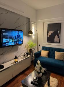 カラチにあるLuxury studio in Dha phase 6の青いソファとテレビのあるリビングルーム
