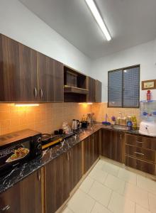 カラチにあるLuxury studio in Dha phase 6の木製のキャビネットとカウンタートップを備えたキッチン