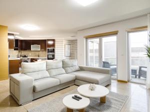 Una sala de estar con un sofá y dos mesas. en Aloha Apartment, en Nazaré