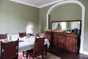 a dining room with a table and a mirror at Hill House Cashel in Cashel