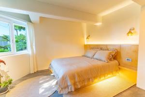 a bedroom with a bed and a window at Jeju Arpore Stay in Jeju