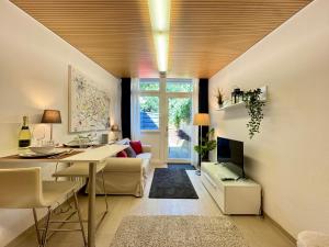 een woonkamer met een tafel en een eetkamer bij Kaiser Wilhelm - Altstadt Design Apartment in Freiburg im Breisgau