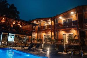 坎多林Tranquillo By The Beach的一栋建筑前有游泳池的度假村