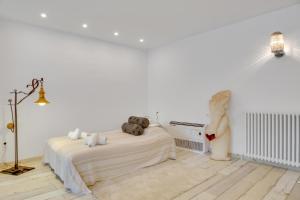 a white bedroom with a bed and a statue at Encantadora casa con terraza y parking en Figueres in Figueres