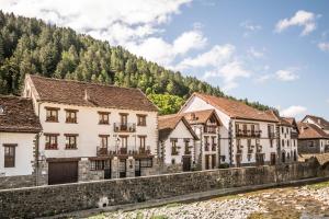 a row of buildings next to a river at Acogedora casa rural a los pies de la Selva Irati in Ochagavía